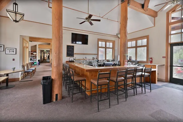 a dining hall with stainless steel appliances kitchen island granite countertop a dining table and chairs