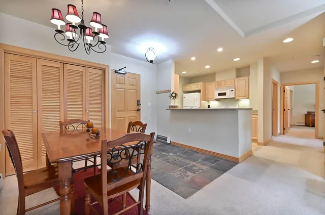 a view of a dining room and livingroom with furniture a chandelier