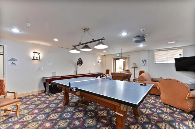a living room with dining table a table and chairs with wooden floor