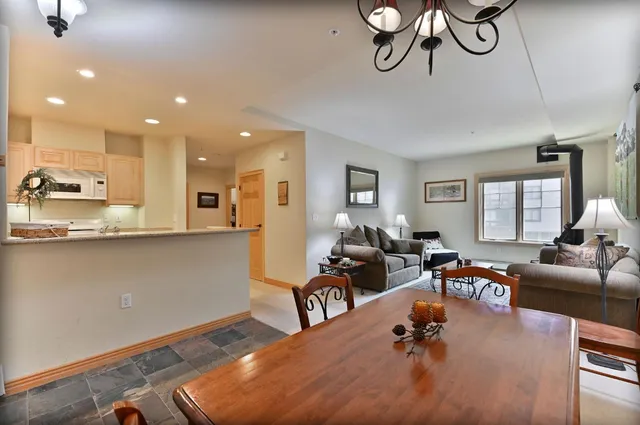 a living room with furniture kitchen view and a wooden floor