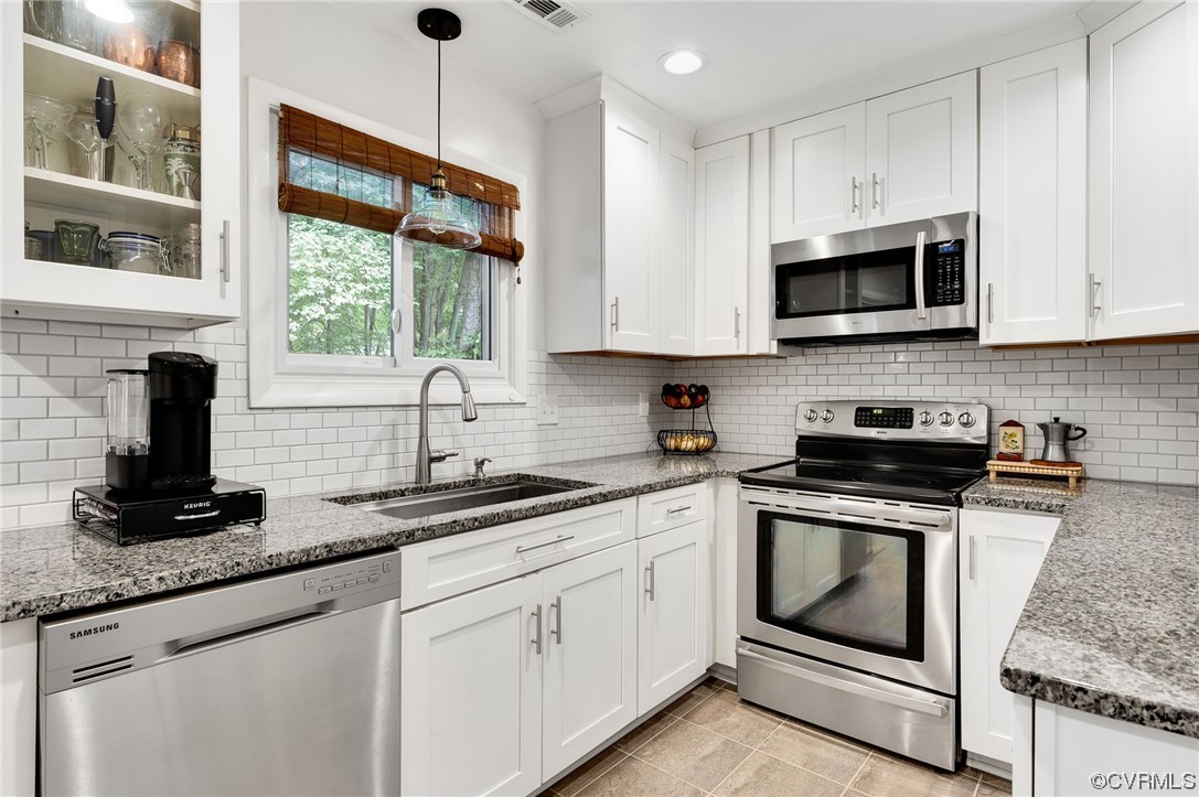 14218 Regatta Pointe Road Midlothian, VA 23112 - Photo 7 of 18 a kitchen with granite countertop white cabinets white stainless steel appliances a sink and a window