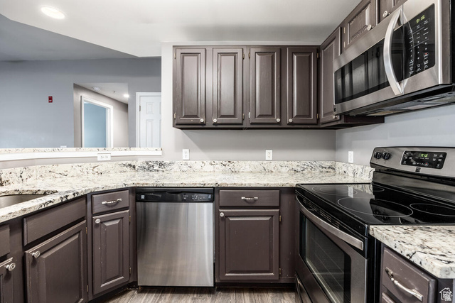 900 Bitner Road, Unit M 17 Park City, UT 84098 - Photo 4 of 29 Kitchen featuring stainless steel appliances, light stone counters, recessed lighting, dark wood finish cabinetry, and light wood-style flooring