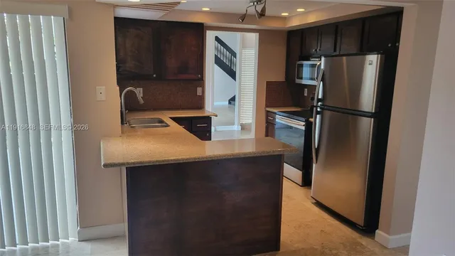 a kitchen with stainless steel appliances a refrigerator and a stove