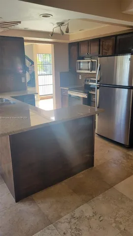 a kitchen with refrigerator and window