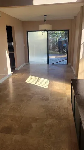 a view of an empty room with a fireplace and a window