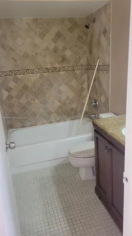 a bathroom with a granite countertop toilet a sink and bathtub