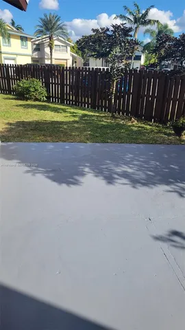 a view of a backyard with wooden fence