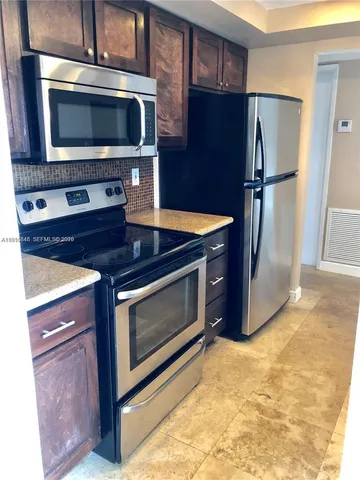a kitchen with stainless steel appliances granite countertop a stove microwave and refrigerator