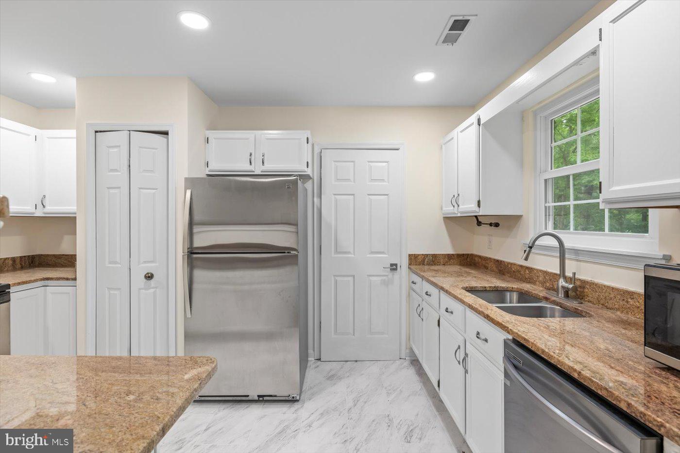 5705 Cascade Drive Fredericksburg, VA 22407 - Photo 13 of 32 a kitchen with kitchen island granite countertop a sink stove and refrigerator