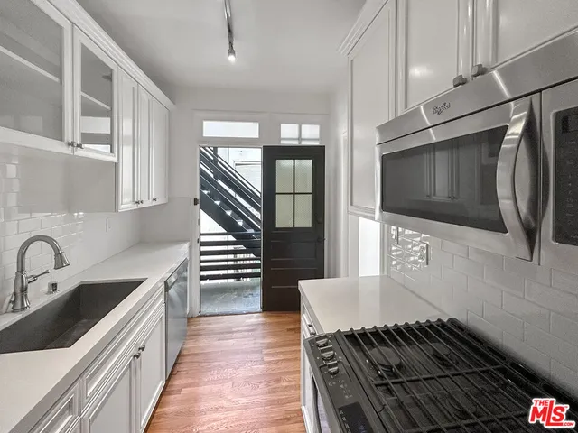 a view of a room with wooden floor and chandelier