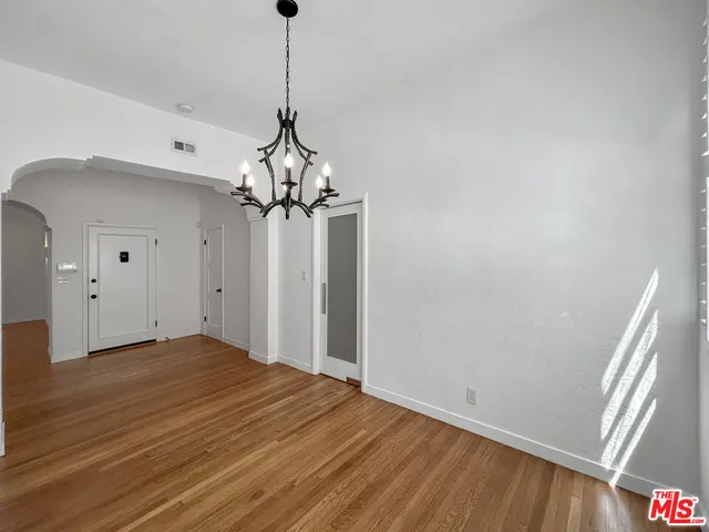 a view of a hallway with wooden floor and closet