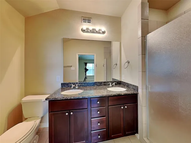 a bathroom with a granite countertop sink and a mirror with toilet