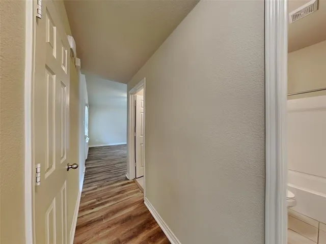 a view of a hallway with wooden floor