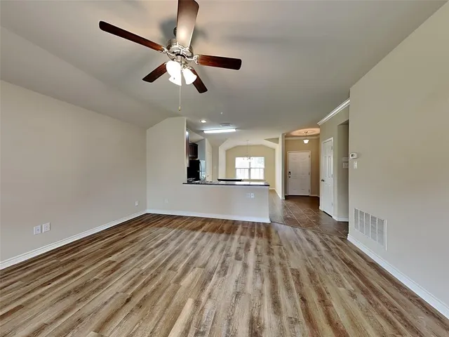 a view of empty room with wooden floor