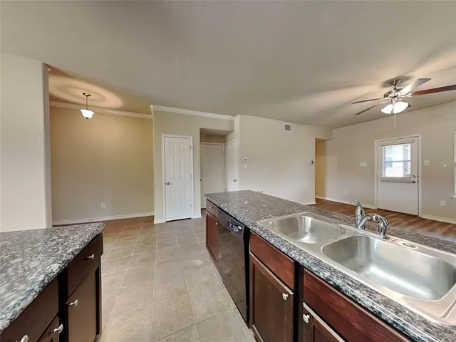 a kitchen with a sink granite counter tops and a stove