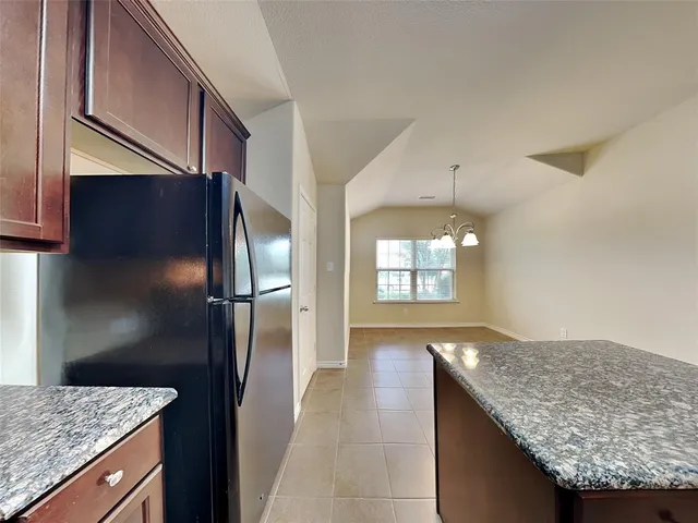 a kitchen with granite countertop cabinets and refrigerator