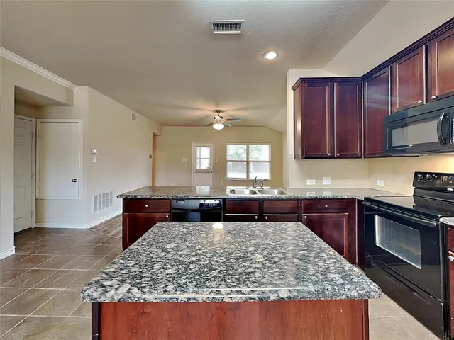 a kitchen with a stove a sink a microwave a refrigerator and cabinets
