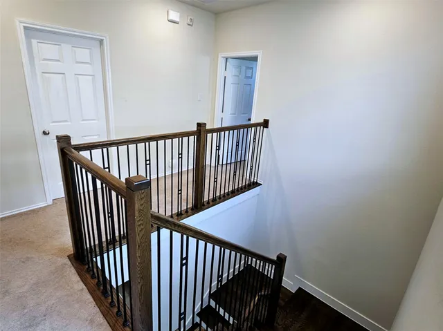 a view of staircase with railing and white walls