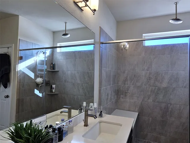 a bathroom with a sink a mirror and a shower