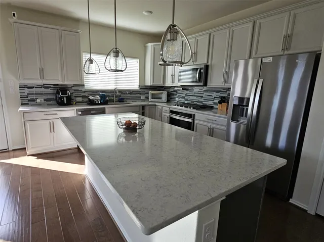 a kitchen with stainless steel appliances granite countertop a sink a stove and refrigerator