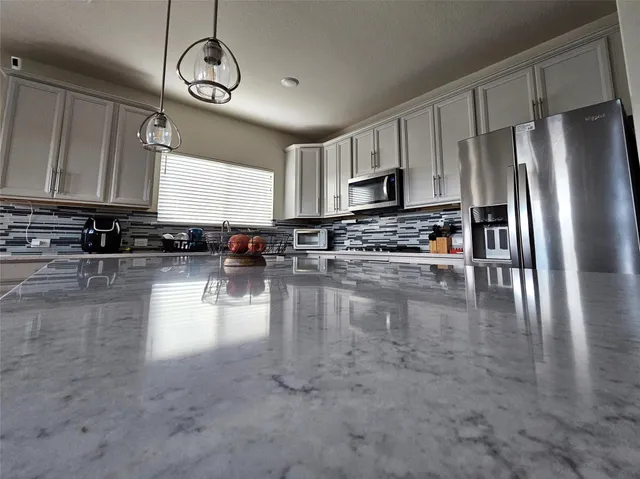 a kitchen with stainless steel appliances granite countertop a stove a refrigerator a sink a stove with wooden cabinets and floor