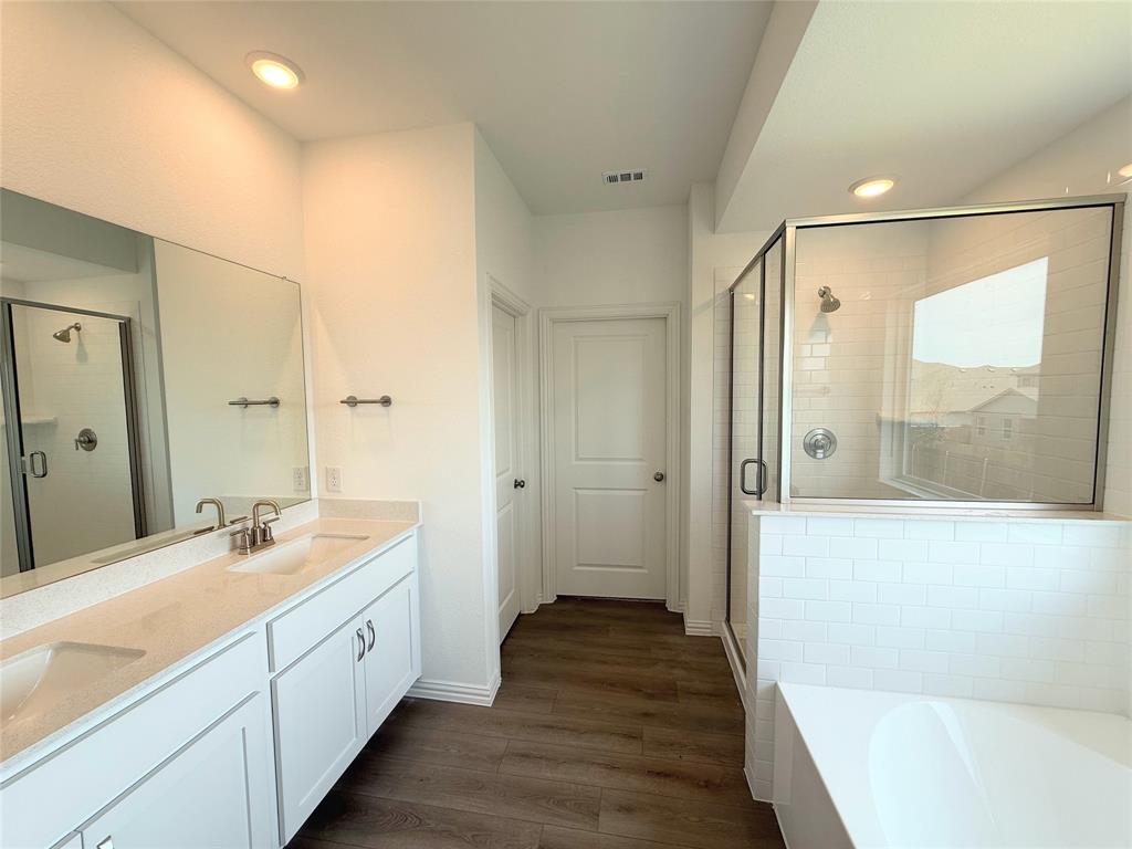 713 Roanoke Drive Princeton, TX 75407 - Photo 16 of 40 Full bathroom with a bath, double vanity, a stall shower, dark wood-style flooring, and recessed lighting