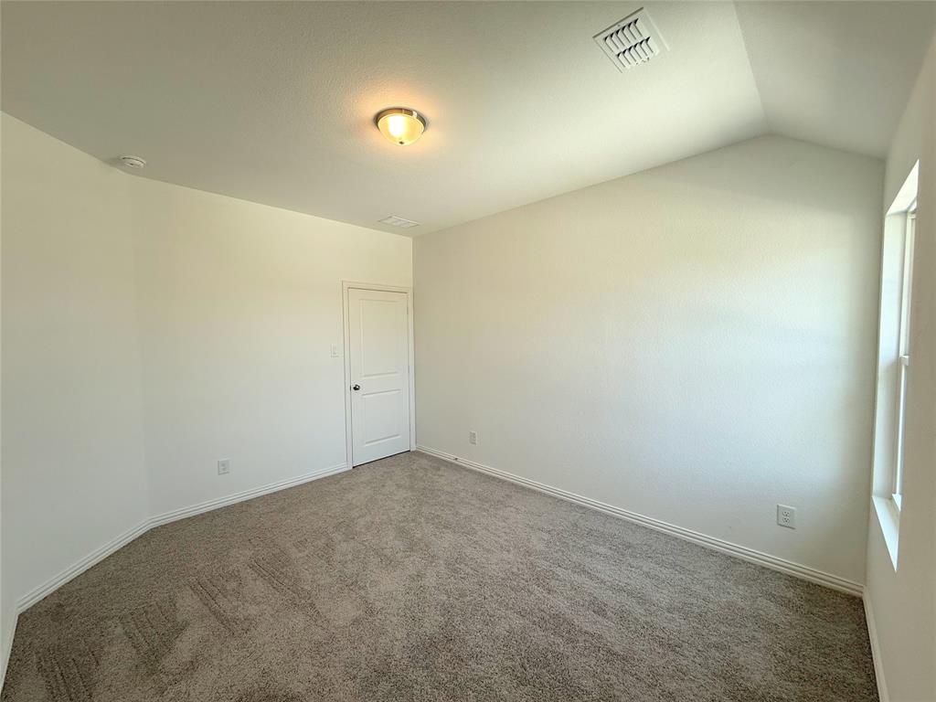713 Roanoke Drive Princeton, TX 75407 - Photo 22 of 40 Carpeted empty room with baseboards and lofted ceiling