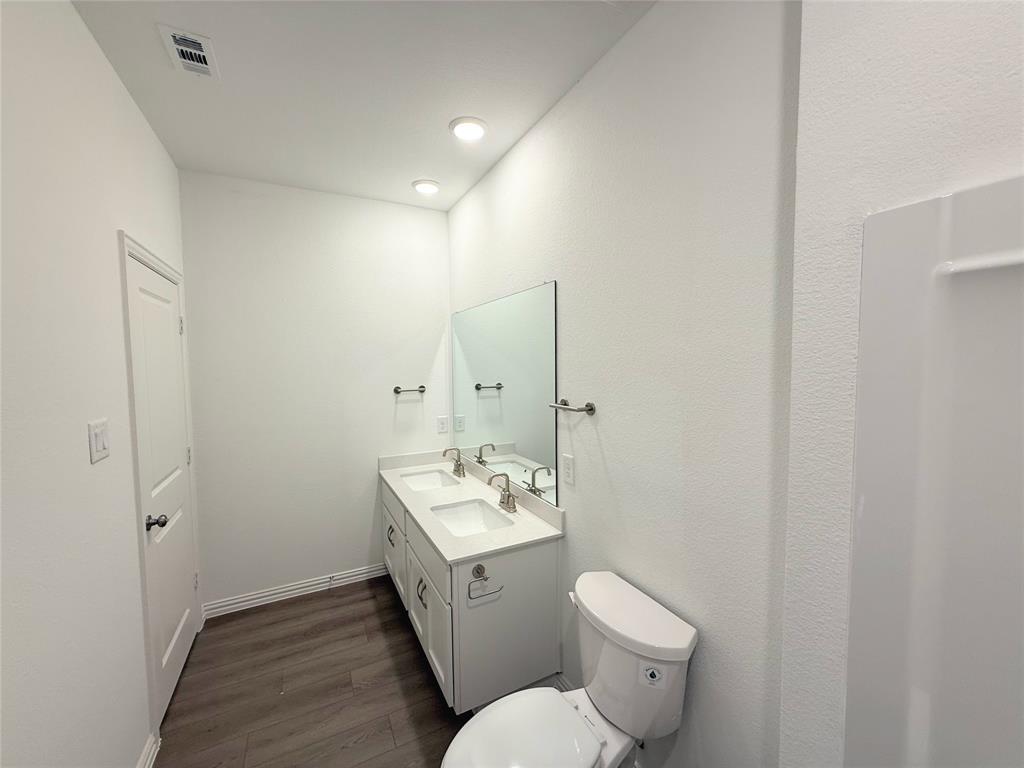 713 Roanoke Drive Princeton, TX 75407 - Photo 25 of 40 Bathroom featuring double vanity and dark wood-style flooring