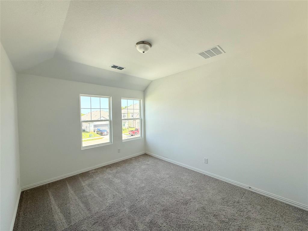 713 Roanoke Drive Princeton, TX 75407 - Photo 26 of 40 Spare room featuring lofted ceiling and carpet
