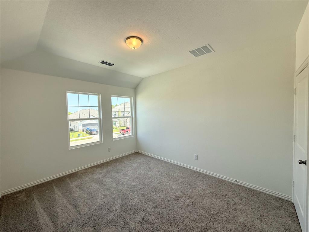 713 Roanoke Drive Princeton, TX 75407 - Photo 27 of 40 Empty room with lofted ceiling and carpet floors