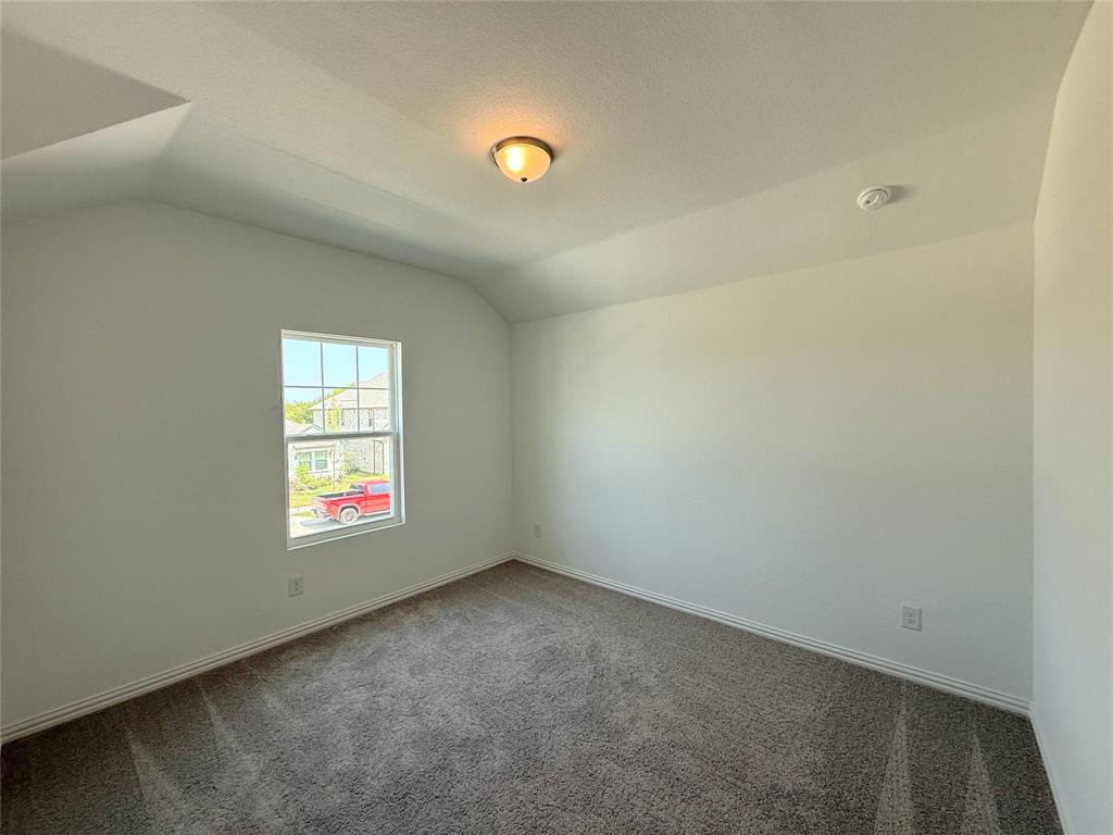 713 Roanoke Drive Princeton, TX 75407 - Photo 29 of 40 Carpeted spare room with lofted ceiling and a textured ceiling