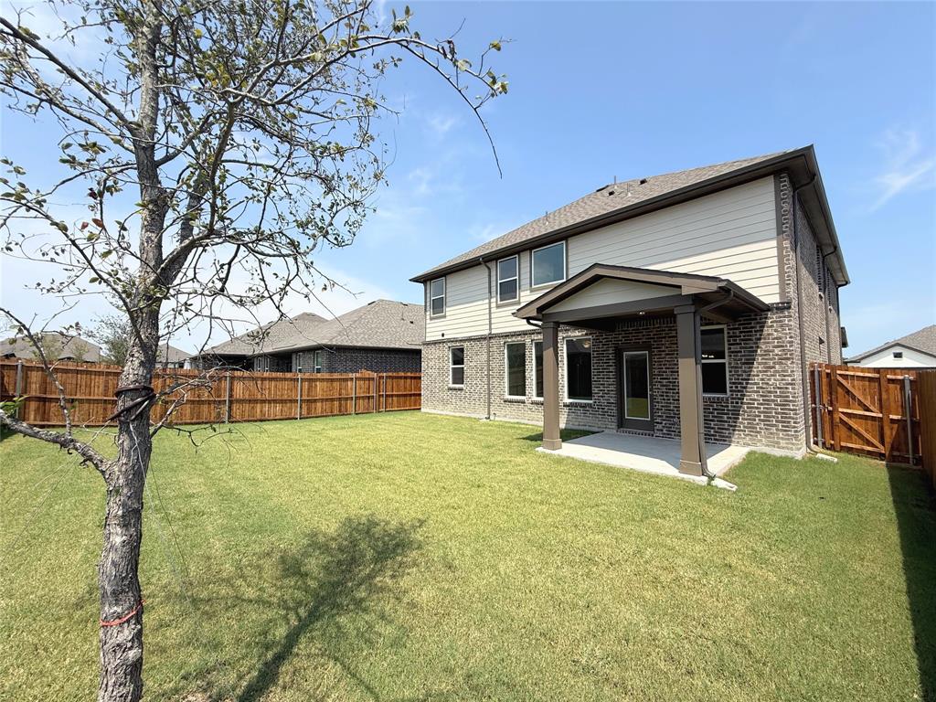 713 Roanoke Drive Princeton, TX 75407 - Photo 34 of 40 Rear view of house with a fenced backyard, brick siding, a patio, and a gate