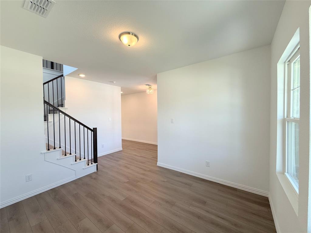 713 Roanoke Drive Princeton, TX 75407 - Photo 4 of 40 Unfurnished living room with stairs and wood finished floors