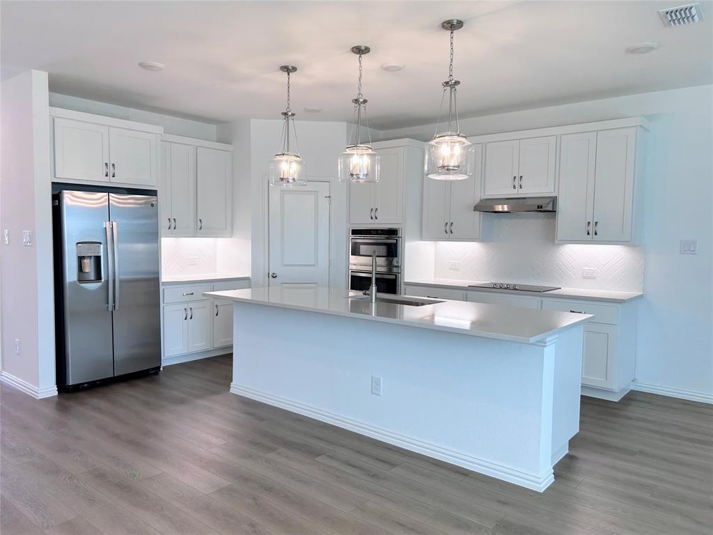 713 Roanoke Drive Princeton, TX 75407 - Photo 8 of 40 Kitchen with appliances with stainless steel finishes, white cabinets, decorative light fixtures, and backsplash