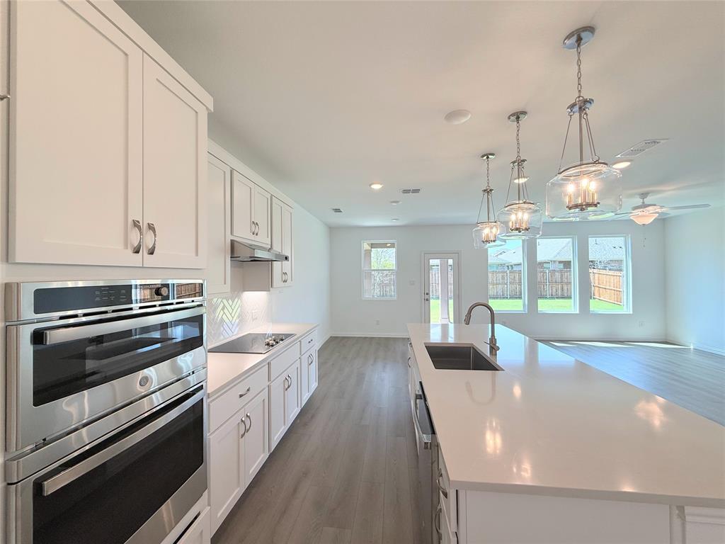 713 Roanoke Drive Princeton, TX 75407 - Photo 10 of 40 Kitchen featuring stainless steel appliances, white cabinetry, an island with sink, and recessed lighting