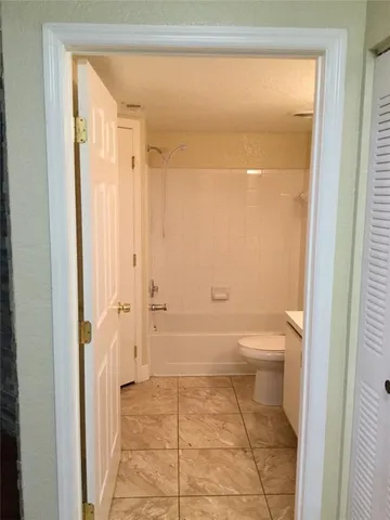 a bathroom with a granite countertop toilet and a shower