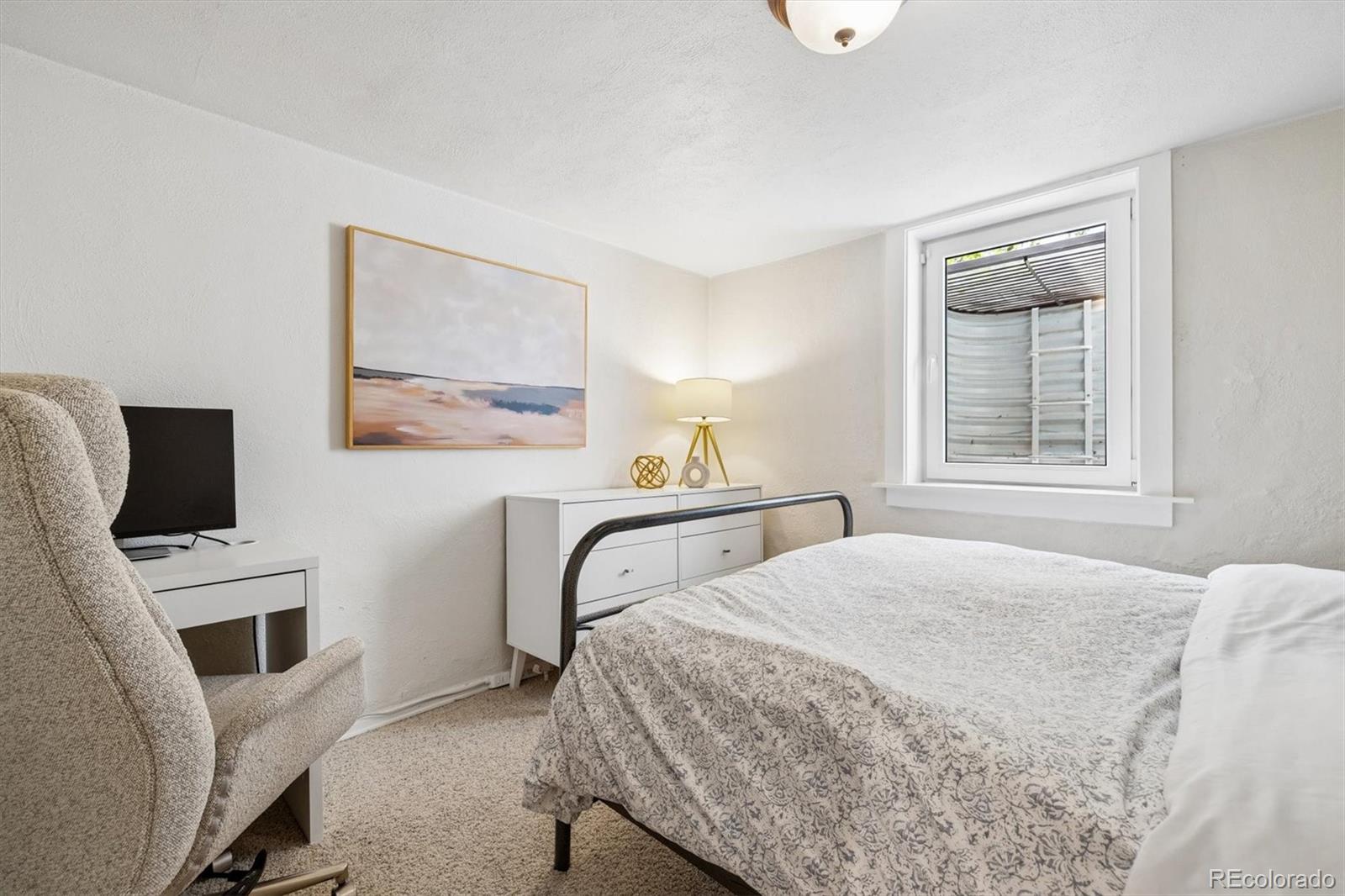 730 Ivanhoe Street Denver, CO 80220 - Photo 28 of 34 a bedroom with a bed a flat tv screen and a dresser