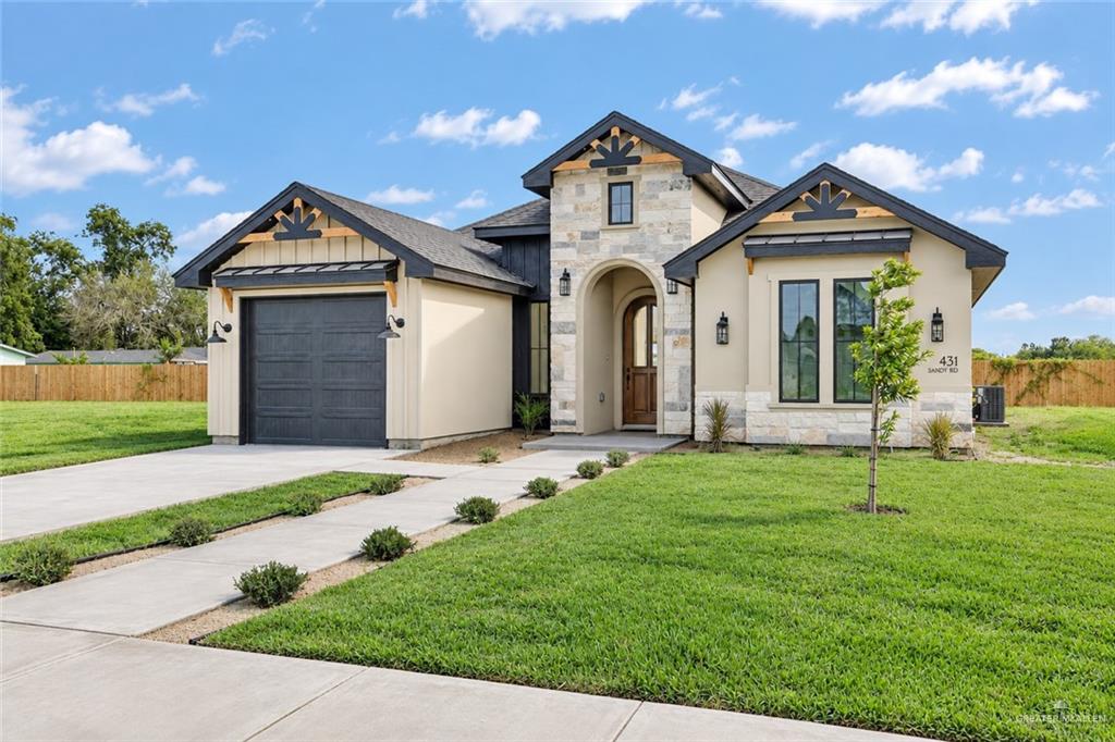 431 Sandy Road Donna, TX 78537 - Photo 2 of 28 Stone and stucco exterior with dark trim accents, featuring a prominent arched entryway