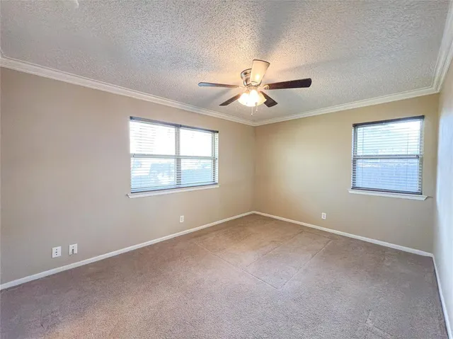 an empty room with a window and a ceiling fan