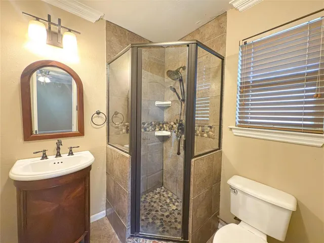 a bathroom with a sink a toilet and shower