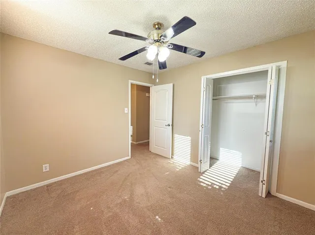 an empty room with closet and fan