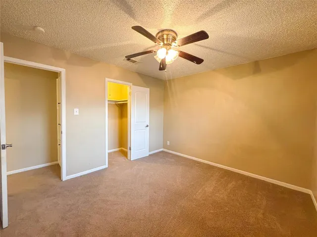 an empty room with a ceiling fan and a window