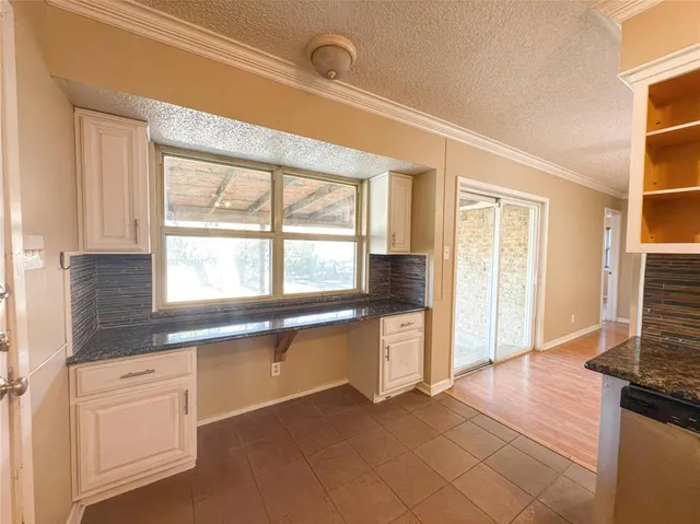 a kitchen with granite countertop a stove a sink and a refrigerator