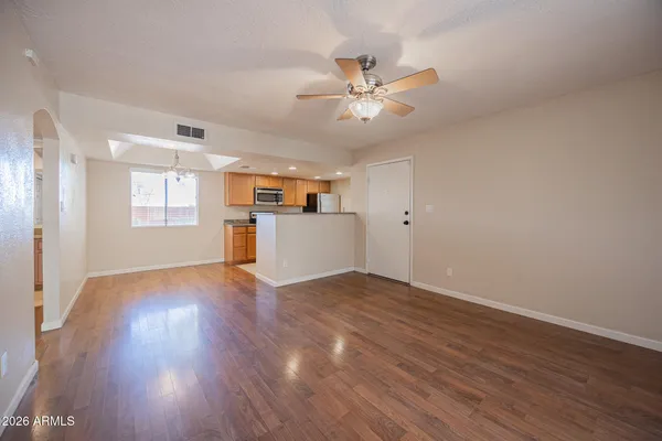 a view of empty room with wooden floor and window