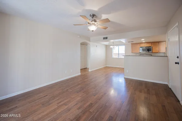 a view of a livingroom with wooden floor and a ceiling fan