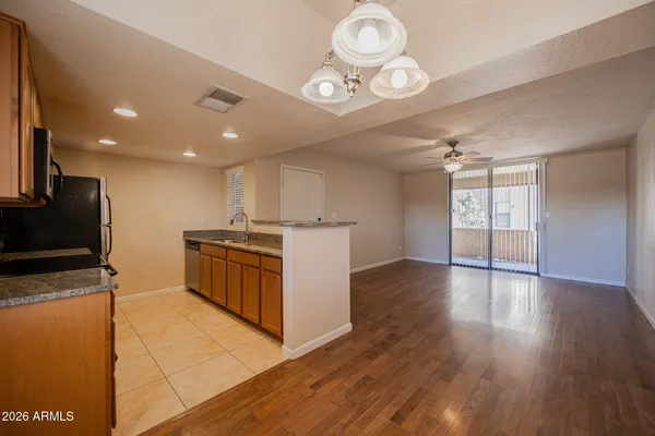a kitchen with stainless steel appliances granite countertop a stove top oven a sink dishwasher and a microwave with wooden floor