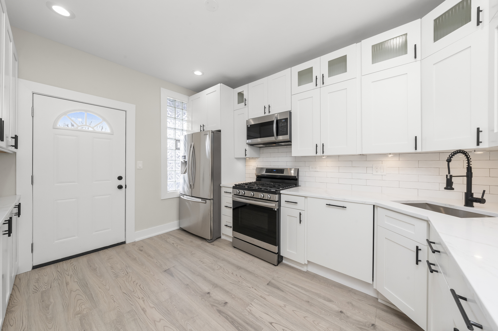 3107 West Flournoy Street Chicago, IL 60612 - Photo 9 of 39 a kitchen with stainless steel appliances white cabinets a sink a stove a refrigerator and white cabinets