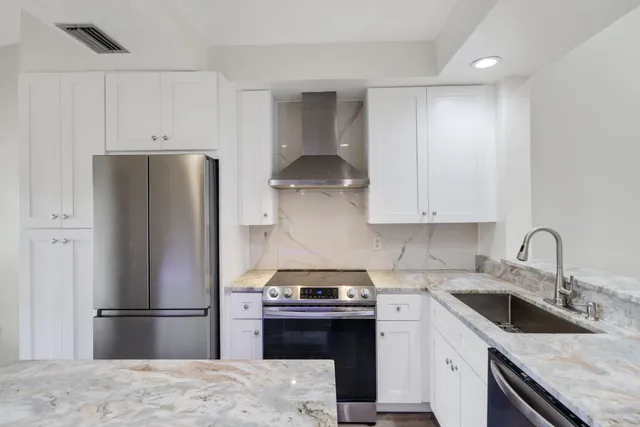 a kitchen with stainless steel appliances granite countertop a sink stove and refrigerator