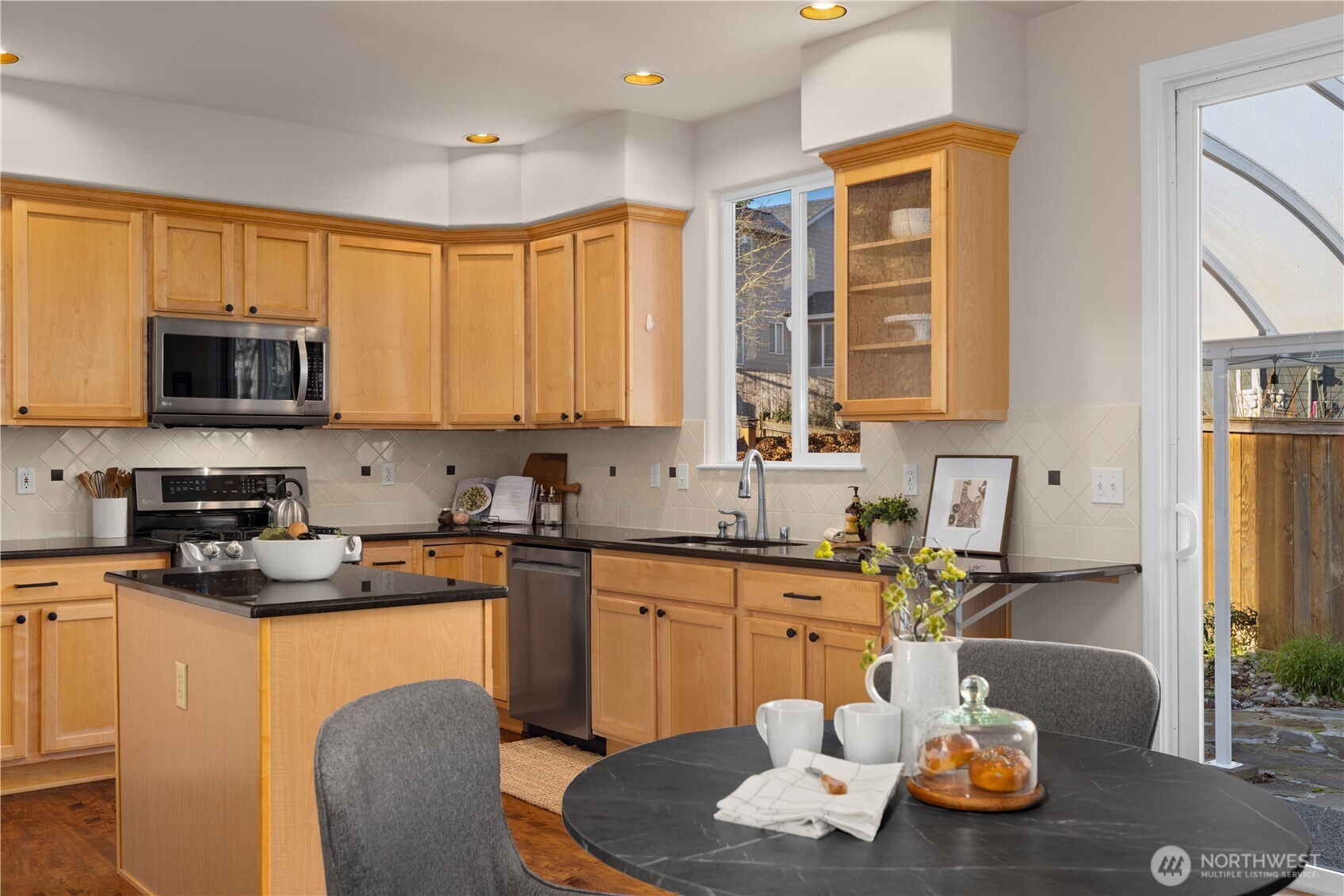 105 202nd Street Southeast Bothell, WA 98012 - Photo 14 of 40 a kitchen with stainless steel appliances granite countertop a sink a stove a refrigerator cabinets and dining table