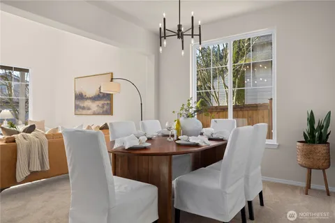 a dining room with furniture a chandelier and window